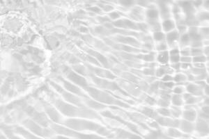 Blue water with ripples on the surface. Defocus blurred transparent blue colored clear calm water surface texture with splashes and bubbles. Water waves with shining pattern texture background. photo
