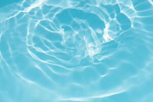 Blue water with ripples on the surface. Defocus blurred transparent blue colored clear calm water surface texture with splashes and bubbles. Water waves with shining pattern texture background. photo
