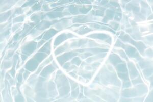 Blue water with ripples on the surface. Defocus blurred transparent blue colored clear calm water surface texture with splashes and bubbles. Water waves with shining pattern texture background. photo