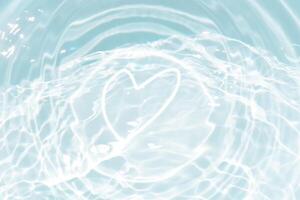 Blue water with ripples on the surface. Defocus blurred transparent blue colored clear calm water surface texture with splashes and bubbles. Water waves with shining pattern texture background. photo