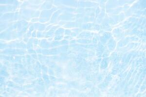Bluewater waves on the surface ripples blurred. Defocus blurred transparent blue colored clear calm water surface texture with splash and bubbles. Water waves with shining pattern texture background. photo