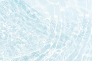 Blue water with ripples on the surface. Defocus blurred transparent blue colored clear calm water surface texture with splashes and bubbles. Water waves with shining pattern texture background. photo
