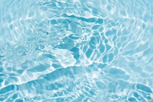 Blue water with ripples on the surface. Defocus blurred transparent blue colored clear calm water surface texture with splashes and bubbles. Water waves with shining pattern texture background. photo