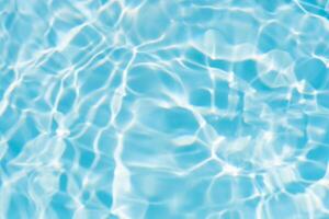 Blue water with ripples on the surface. Defocus blurred transparent blue colored clear calm water surface texture with splashes and bubbles. Water waves with shining pattern texture background. photo