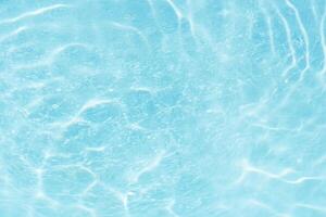 Blue water with ripples on the surface. Defocus blurred transparent blue colored clear calm water surface texture with splashes and bubbles. Water waves with shining pattern texture background. photo