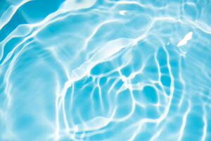 Blue water with ripples on the surface. Defocus blurred transparent blue colored clear calm water surface texture with splashes and bubbles. Water waves with shining pattern texture background. photo