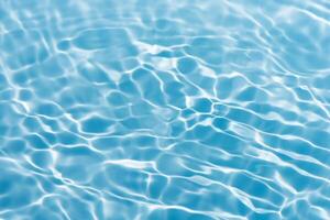 Blue water with ripples on the surface. Defocus blurred transparent blue colored clear calm water surface texture with splashes and bubbles. Water waves with shining pattern texture background. photo