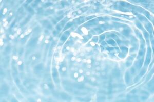 Blue water with ripples on the surface. Defocus blurred transparent blue colored clear calm water surface texture with splashes and bubbles. Water waves with shining pattern texture background. photo