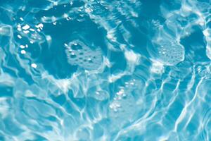 Blue water with ripples on the surface. Defocus blurred transparent blue colored clear calm water surface texture with splashes and bubbles. Water waves with shining pattern texture background. photo
