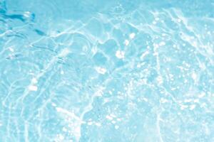 Bluewater waves on the surface ripples blurred. Defocus blurred transparent blue colored clear calm water surface texture with splash and bubbles. Water waves with shining pattern texture background. photo