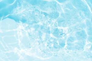 Bluewater waves on the surface ripples blurred. Defocus blurred transparent blue colored clear calm water surface texture with splash and bubbles. Water waves with shining pattern texture background. photo