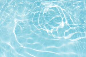 Bluewater waves on the surface ripples blurred. Defocus blurred transparent blue colored clear calm water surface texture with splash and bubbles. Water waves with shining pattern texture background. photo