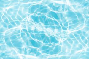 Bluewater waves on the surface ripples blurred. Defocus blurred transparent blue colored clear calm water surface texture with splash and bubbles. Water waves with shining pattern texture background. photo