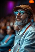 Man with beard and glasses sits in the audience and watches the performance. photo