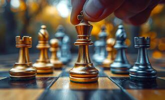 A closeup of the hand moving one golden and silver chess piece on an empty game board photo