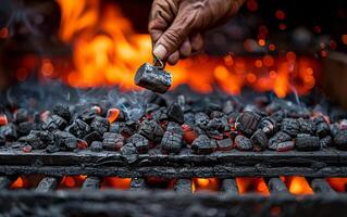 Man is grilling charcoal on grill with fire in the background photo