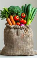 Burlap sack filled with fresh vegetables photo