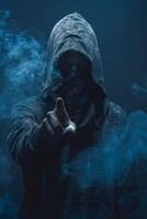 Mysterious man in hood pointing the finger in the camera in the dark photo