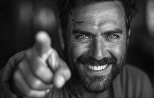 Man smiles and points at the camera. photo