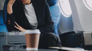 Attractive asian female passenger of airplane sitting in comfortable seat listening music in earphones while working at modern laptop computer with mock up area using wireless connection on board. video