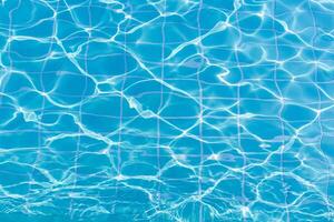 Blue swimming pool water surface and ripple wave background. Summer abstract reflection caustics in swimming pool. photo