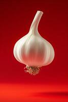 A classic portrait of a garlic bulb showcased against a deep red background, highlighting its natural elegance and symmetry. photo