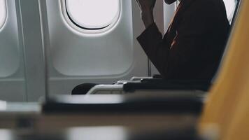 Woman hand using smart phone on airplane. Female traveler using smart phone in passenger cabin. Can be add your texts or others on screen. Sun shining trough airplane window. Technology concept. video