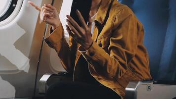 Woman hand using smart phone on airplane. Female traveler using smart phone in passenger cabin. Can be add your texts or others on screen. Sun shining trough airplane window. Technology concept. video