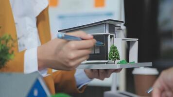 Architecture team and engineer are discussing and brainstorming on floor plan over the clean energy and power saving house design using solar panel for green industry and futuristic home development video