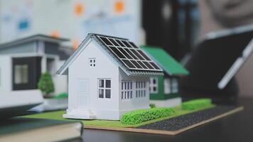 Architecture team and engineer are discussing and brainstorming on floor plan over the clean energy and power saving house design using solar panel for green industry and futuristic home development video
