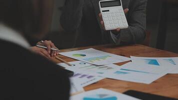 Financial analysts analyze business financial reports on a digital tablet planning investment project during a discussion at a meeting of corporate showing the results of their successful teamwork. video