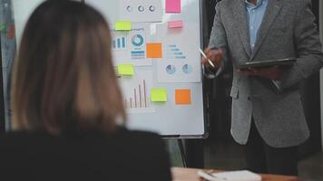 Financial analysts analyze business financial reports on a digital tablet planning investment project during a discussion at a meeting of corporate showing the results of their successful teamwork. video