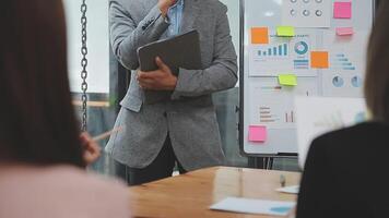 Financial analysts analyze business financial reports on a digital tablet planning investment project during a discussion at a meeting of corporate showing the results of their successful teamwork. video