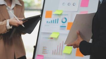Financial analysts analyze business financial reports on a digital tablet planning investment project during a discussion at a meeting of corporate showing the results of their successful teamwork. video