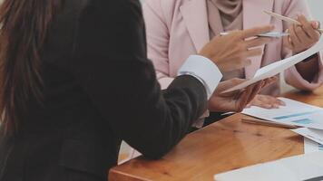 Financial analysts analyze business financial reports on a digital tablet planning investment project during a discussion at a meeting of corporate showing the results of their successful teamwork. video