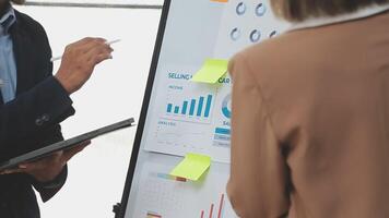 Financial analysts analyze business financial reports on a digital tablet planning investment project during a discussion at a meeting of corporate showing the results of their successful teamwork. video