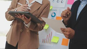 Financial analysts analyze business financial reports on a digital tablet planning investment project during a discussion at a meeting of corporate showing the results of their successful teamwork. video