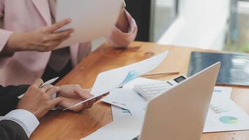 Financial analysts analyze business financial reports on a digital tablet planning investment project during a discussion at a meeting of corporate showing the results of their successful teamwork. video