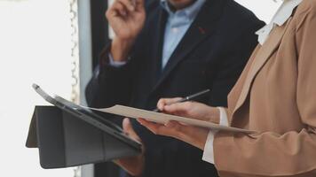 Financial analysts analyze business financial reports on a digital tablet planning investment project during a discussion at a meeting of corporate showing the results of their successful teamwork. video