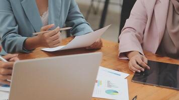 Financial analysts analyze business financial reports on a digital tablet planning investment project during a discussion at a meeting of corporate showing the results of their successful teamwork. video