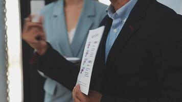Financial analysts analyze business financial reports on a digital tablet planning investment project during a discussion at a meeting of corporate showing the results of their successful teamwork. video