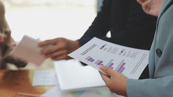 Financial analysts analyze business financial reports on a digital tablet planning investment project during a discussion at a meeting of corporate showing the results of their successful teamwork. video