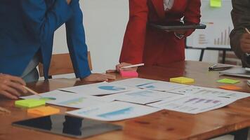 Financial analysts analyze business financial reports on a digital tablet planning investment project during a discussion at a meeting of corporate showing the results of their successful teamwork. video