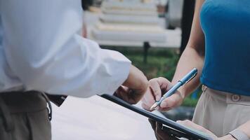Insurance agent writing on clipboard while examining car after accident claim being assessed and processed video