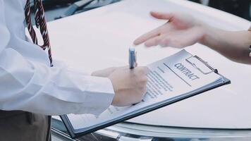 Insurance agent writing on clipboard while examining car after accident claim being assessed and processed video