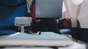 Attractive asian female passenger of airplane sitting in comfortable seat listening music in earphones while working at modern laptop computer with mock up area using wireless connection on board. video