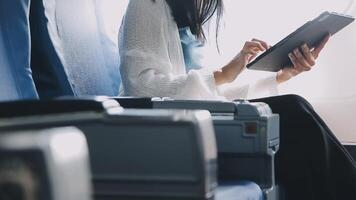Attractive asian female passenger of airplane sitting in comfortable seat listening music in earphones while working at modern laptop computer with mock up area using wireless connection on board. video