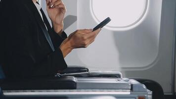 Attractive asian female passenger of airplane sitting in comfortable seat listening music in earphones while working at modern laptop computer with mock up area using wireless connection on board. video