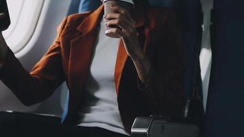 Woman hand using smart phone on airplane. Female traveler using smart phone in passenger cabin. Can be add your texts or others on screen. Sun shining trough airplane window. Technology concept. video