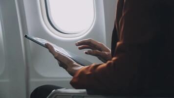 Woman hand using smart phone on airplane. Female traveler using smart phone in passenger cabin. Can be add your texts or others on screen. Sun shining trough airplane window. Technology concept. video